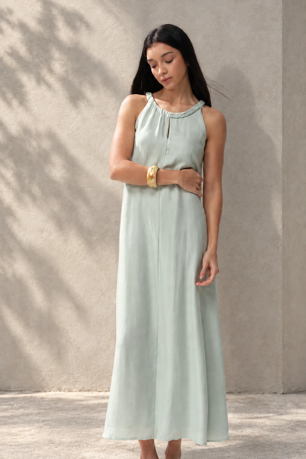 Green dress against a quiet sunlit wall